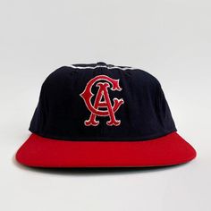 "Here is a rare display item from the \"Golden Age of Baseball\". Offered is an original California Angels KM Pro cap from the 1960s. The cap features the California Angels interlocking \"CA\" logo on the front, red bill and silver halo stitched around the crown. The six-point crown suspension's interior is lined with a leather sweatband that is home to a vintage \"KM Pro\" label. This cap is labeled as a size \"7\". Features - Color: navy, silver and red - Interlocking \"CA\" logo on the front Retro Flat Brim Hats For Baseball Season, Retro Style Fitted Baseball Cap For Baseball Season, Retro Fitted Hat For Baseball Season With Flat Bill, Retro Flat Brim Snapback Hat For Baseball Season, Retro Fitted Hat With Flat Brim For Baseball Season, Vintage Flat Brim Trucker Hat For Baseball Season, Retro Flat Brim Hat For Sports Events, Retro Hat With Embroidered Logo For Baseball Season, Vintage Flat Brim Baseball Cap For Baseball Season