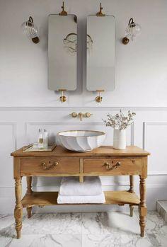 a bathroom with two sinks and mirrors on the wall