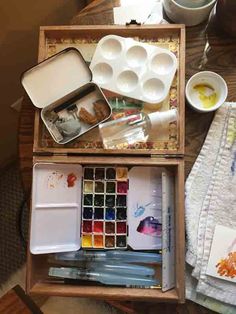 an artist's box filled with paint, watercolors and other art supplies