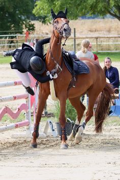 a woman riding on the back of a brown horse