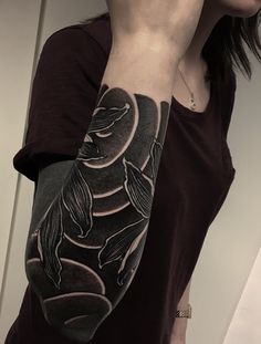 a woman with a black and white tattoo on her arm