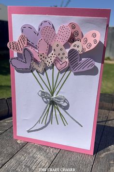 a handmade card with paper hearts on it and a bow tied around the heart