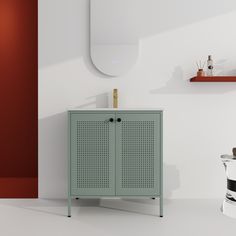 a green cabinet sitting next to a sink in a room with white walls and flooring