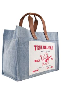 The oversized logo stamps a signature finish on a squared tote bag with leatherette top handles to comfortably carry beach gear or picnic essentials in style. 13.5" x 18" x 8" D Magnetic top closure Dual top handles Exterior has 1 slip pocket Interior has 3 slip pockets, 1 zip pocket Cotton/polyester Lined Imported Homesteading Animals, Jeans Large, Picnic Essentials, Creation Station, Denim Tote Bags, Beach Gear, Denim Tote, Logo Stamp