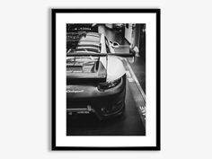 a black and white photo of cars parked in a parking garage with their hoods down