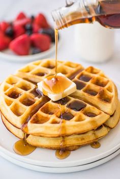 syrup being drizzled onto a stack of waffles