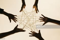 several hands reaching up towards the center of a string - work star, in silhouette against a white background