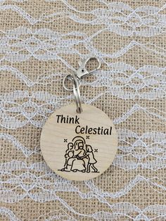 a wooden keychain with the words think celestal on it and an image of two people