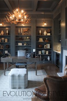 a living room filled with furniture and a chandelier hanging from the ceiling over a fire place