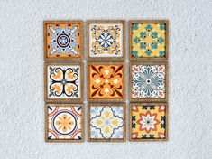 nine colorful tiles arranged in squares on a white wall