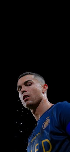 a man is sprinkled with water on his face while standing in front of a black background