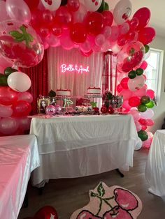 a table topped with lots of pink and white balloons