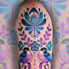 an artistically painted leg with birds and flowers on the top part of its legs