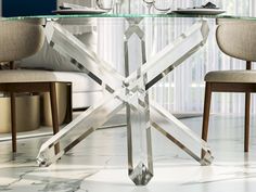 a glass dining table with chairs around it