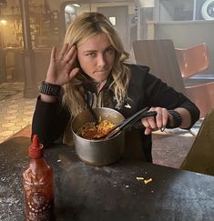 a woman sitting at a table with a bowl of food