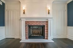 an empty living room with a fireplace and two lights on either side of the fire place