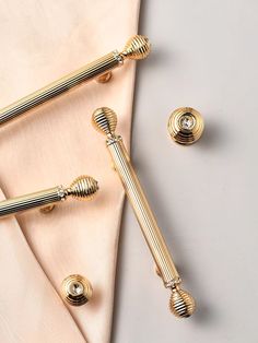 two gold - plated metal handles on a pink satin sheet and matching napkins