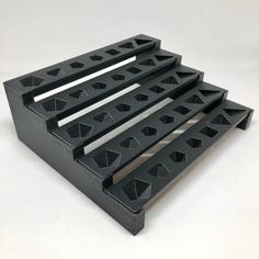 four black plastic trays stacked on top of each other with holes in the middle