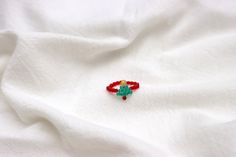 a red and green pin sitting on top of a white sheet