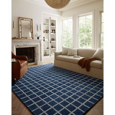 a living room filled with furniture and a blue rug on top of a wooden floor