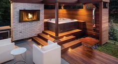 a hot tub sitting on top of a wooden deck next to a white chair and table