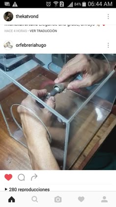 someone is working on something in a clear box