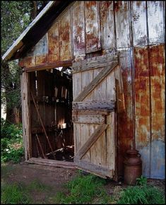 an old barn door is open to reveal the contents in the shed that has been abandoned