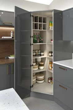 an open pantry in the middle of a kitchen with white counter tops and gray cabinets