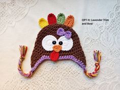 a crocheted turkey hat with tassels on it's head and eyes