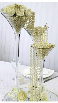 two tall vases filled with pearls and flowers