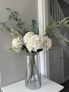 a vase filled with white flowers on top of a table