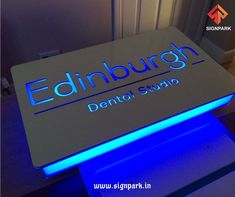 an illuminated sign for edinburgh dental studio on the floor in front of a door and window