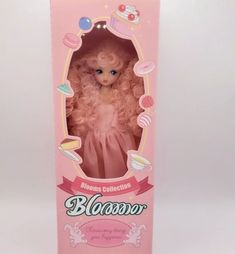 a doll in a pink box on a white background