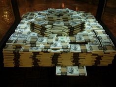 stacks of money sitting on top of each other in front of a glass display case