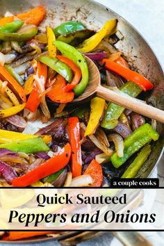 a pan filled with peppers and onions on top of a table next to a wooden spoon