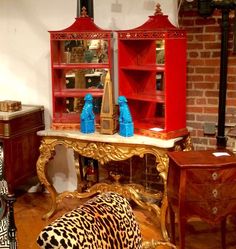 a living room filled with furniture next to a fire place covered in leopard print pillows