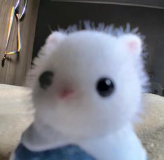 a small white stuffed animal sitting on top of a table