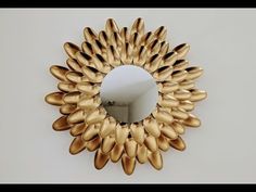 a mirror that has some gold leaves in the shape of a sunflower on it