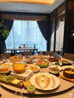 a large table filled with lots of plates and bowls full of food on top of it