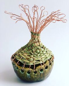 a green vase with some kind of wire on it's top and the bottom