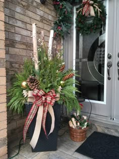 the front door is decorated for christmas with evergreens and pine cone wreaths on it