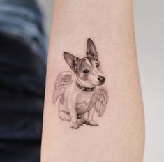 a small dog with angel wings on its arm is shown in black and grey ink