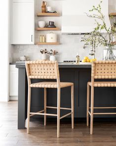 two wooden chairs sitting next to each other in a kitchen