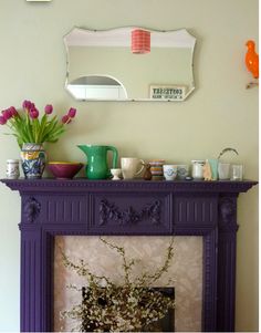 a living room with a purple fireplace and vases on top of the mantel