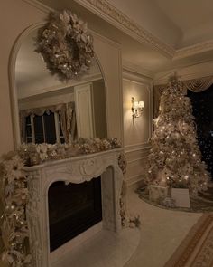 a living room decorated for christmas with a fire place and mirror on the wall above it