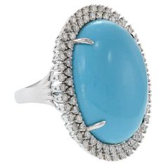 Elegance meets sparkling vitality in this 18kt white gold cocktail ring. A large, natural oval turquoise stone sits surrounded by 1.47 carats (total weight) of diamonds (F-G color, VS clarity). Size 6.75 US. Weight 14.1 gm. Oval Diamond Turquoise Ring For Formal Occasions, Formal Oval Turquoise Ring With Diamond, Luxury Oval Turquoise Gemstone Ring, Oval Cocktail Ring, Oval Turquoise Ring With Diamond Accents, Elegant Turquoise Cabochon Diamond Ring, Luxury Elegant Turquoise Oval Cabochon Ring, Luxury Oval Cabochon Turquoise Gemstone Ring, Collectible Multi-stone Turquoise Oval Ring