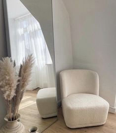 a white chair sitting next to a tall mirror