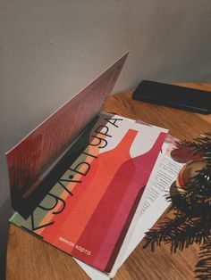 there are three magazines on the table next to a christmas tree and a cell phone