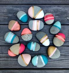 colorful painted rocks arranged in a circle on a wooden surface