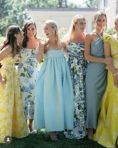 a group of women standing next to each other on top of a lush green field